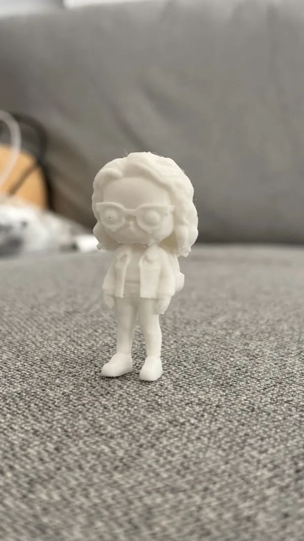 The generated figure 3D printed in white, standing on a couch
